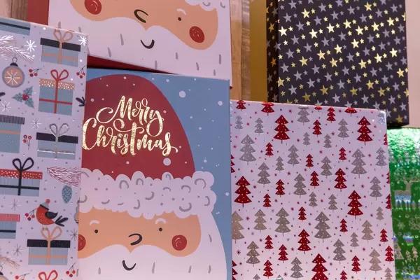 Weihnachtliche Poster mit Geschenken, Weihnachtsbäumen und Sternen verziert