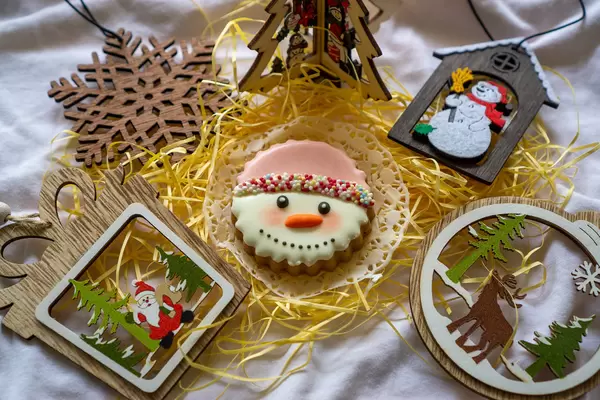 Weihnachts-Deko wie Weihnachtsbaum, Schneeflocke und Weihnachtsmann um ein Schneemann Gesicht als Lebkuchen Plätzchen mit Zuckerperlen und Zuckerguss Dekoration