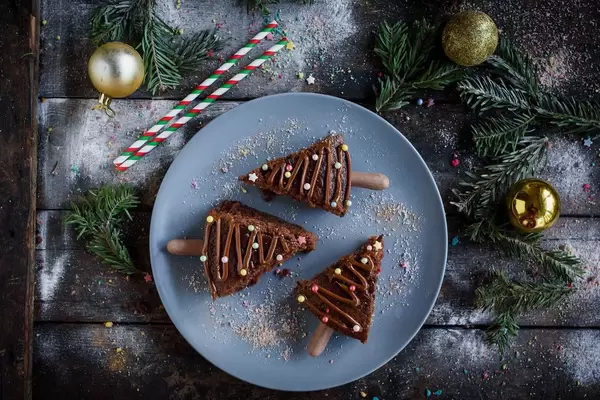 Weihnachts Schokoladenkuchen auf blauem Teller mit Tannenzweigen