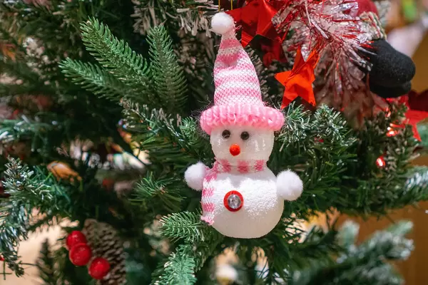 Weihnachtsbaum Dekoration im Schneemann-Design mit Mütze und Schal neben Sternen und Weihnachtsmann Nahaufnahme