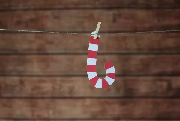 Weihnachtsdeko Zuckerstange hängt an Leine