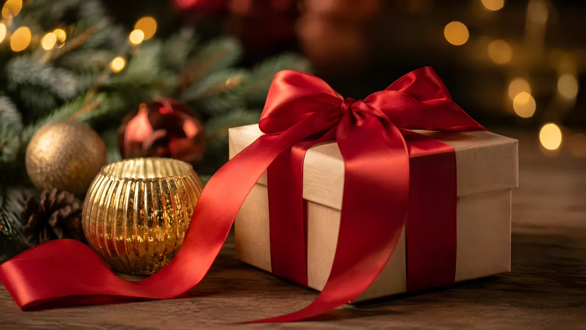 Weihnachtsgeschenk mit roter Schleife und Deko
