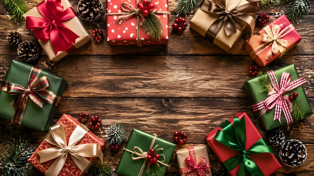 Weihnachtsgeschenke auf rustikalem Holztisch arrangiert