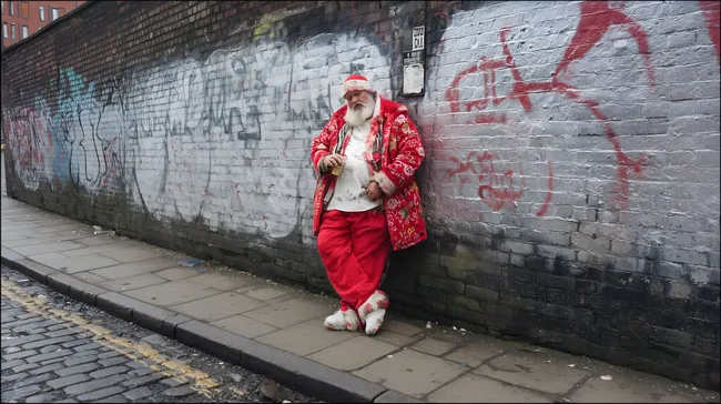 Weihnachtsmann in rotem Outfit vor Graffitiwand