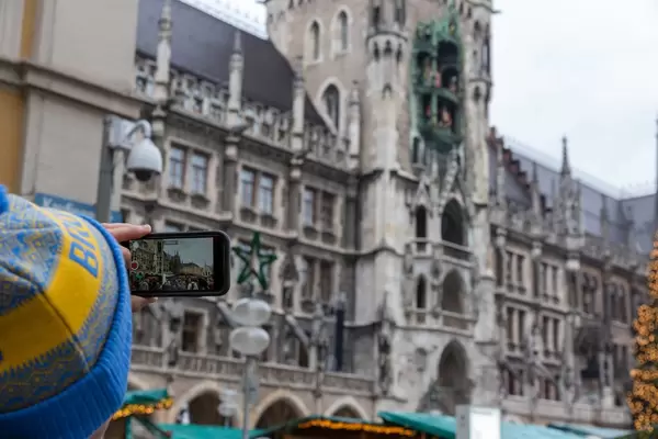 Weihnachtsmarktbesucher benutzt Smartphone für Video von Kölner Dom und Markt