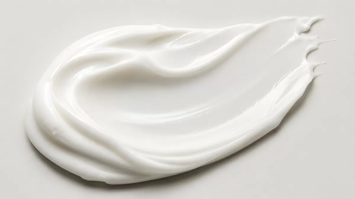 Weiße Creme als glänzender Strich auf hellem Grund