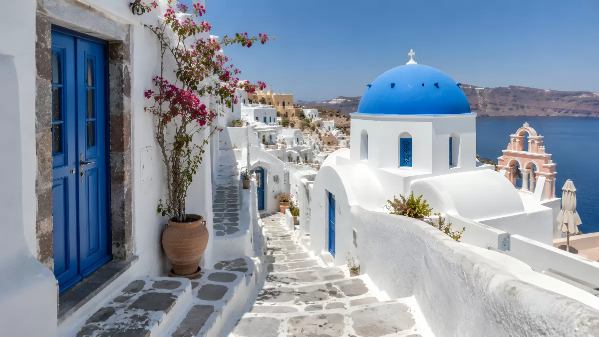Weiße Gassen und blaue Kuppelkirche in Santorin