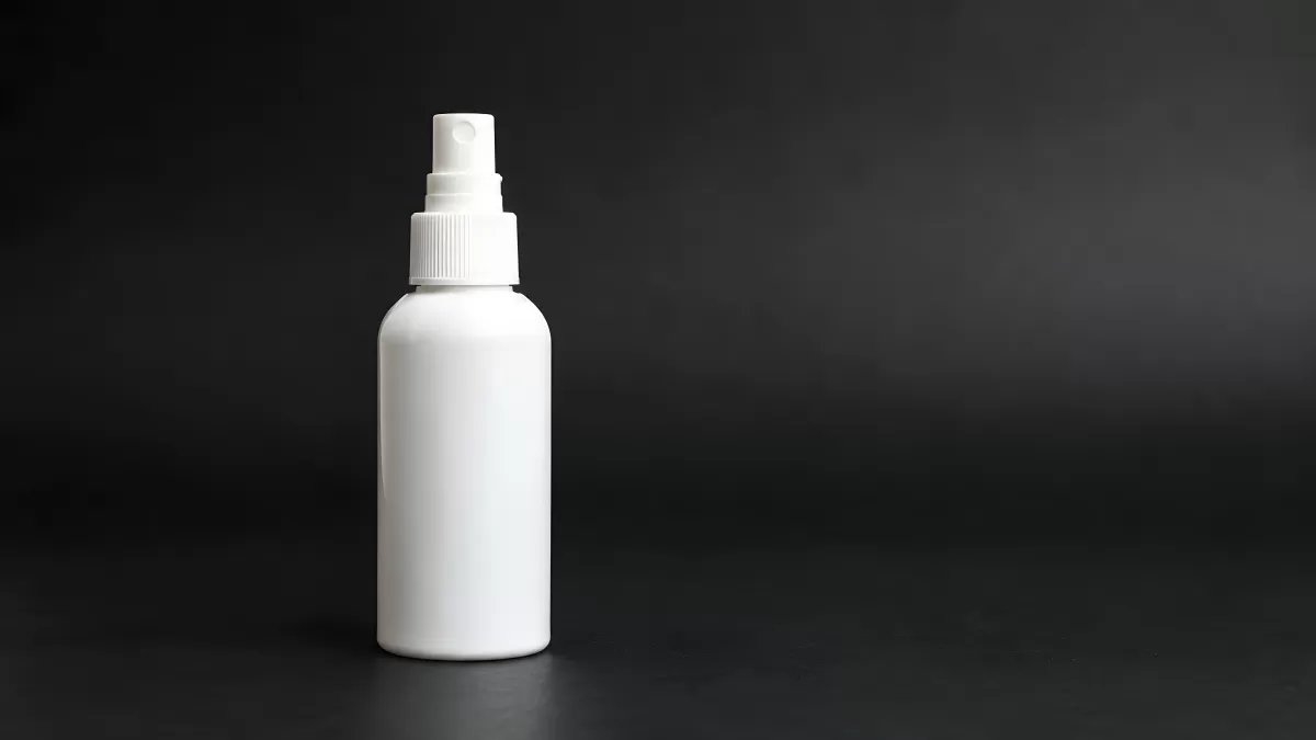 Weiße Sprühflasche vor dunklem Hintergrund