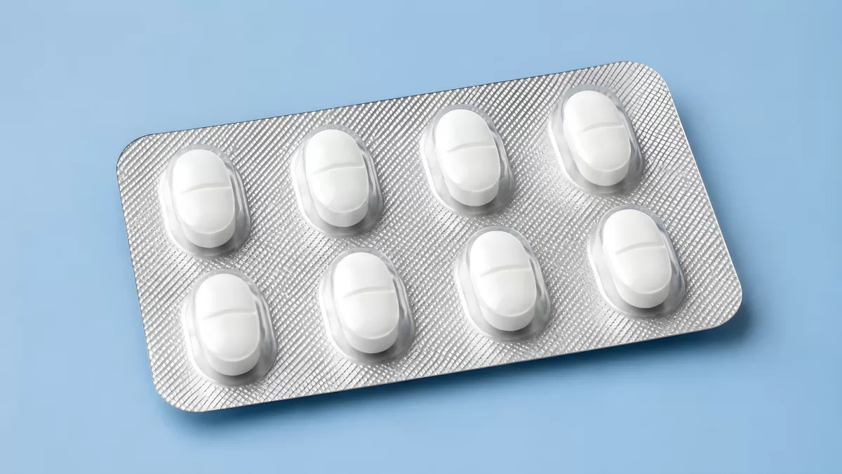 Weiße Tabletten in Silber-Blisterpackung auf Blau