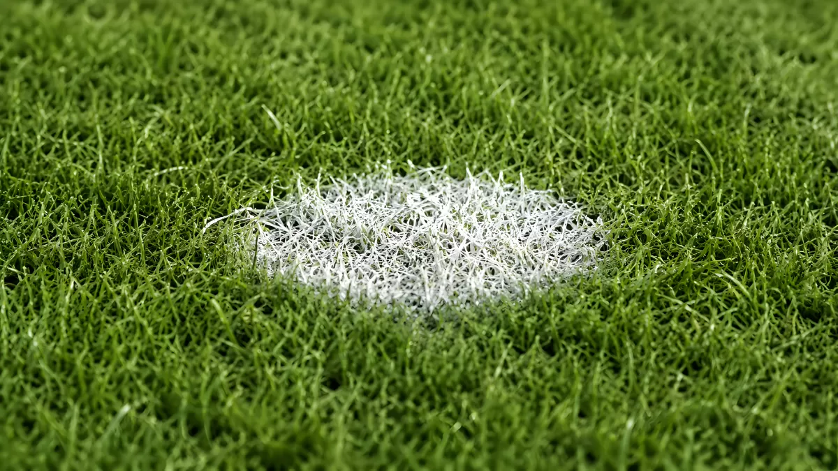 Weißer Mittelpunkt auf grünem Fußballrasen Nahaufnahme
