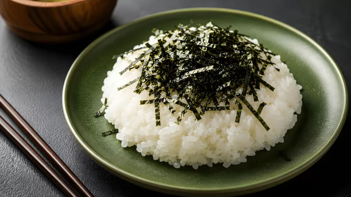 Weißer Reis mit Nori-Streifen auf grünem Teller