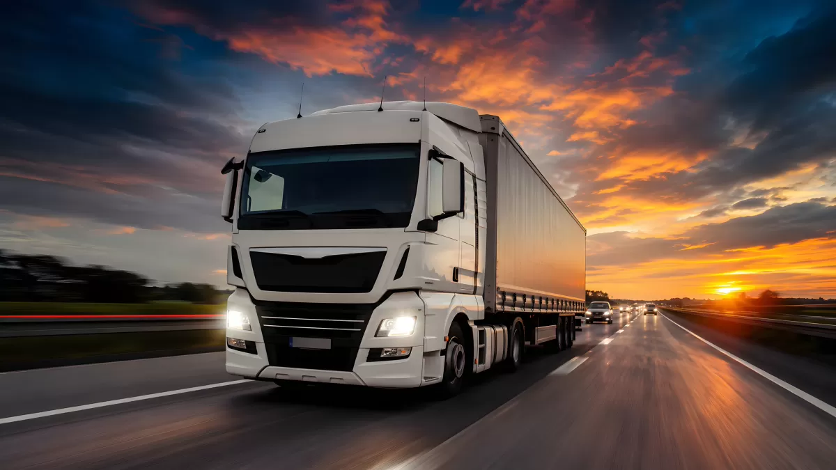 Weißer Sattelzug auf Autobahn bei Sonnenuntergang