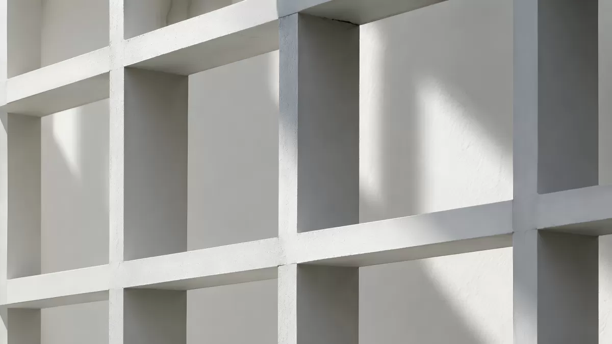 Weißes Betonraster mit Licht und Schatten an Fassade