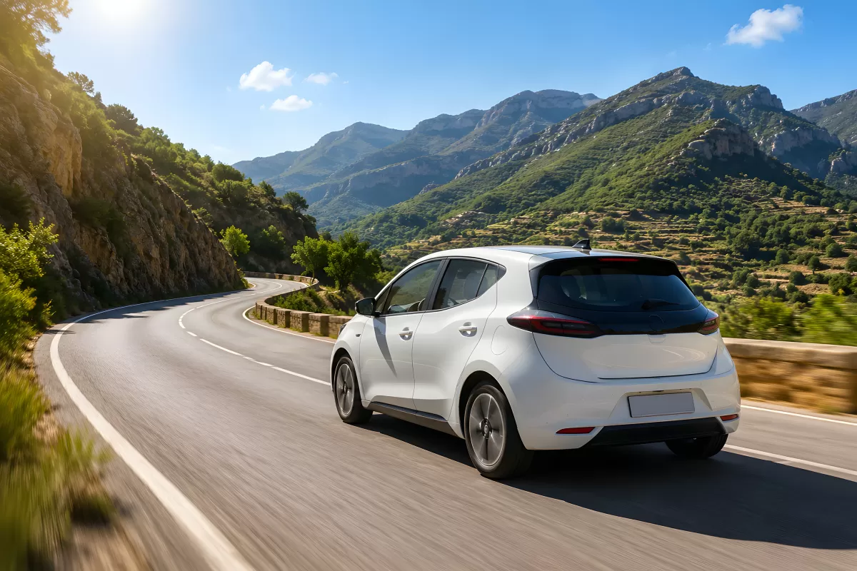 Weißes Elektroauto auf kurvenreicher Bergstraße