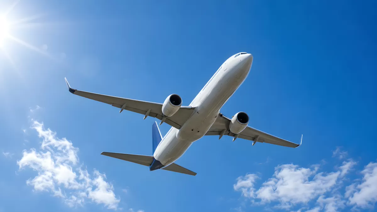 Weißes Passagierflugzeug am blauen Sommerhimmel