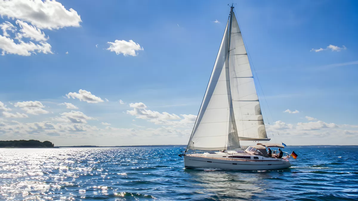 Weißes Segelboot auf blauem Meer bei Sonnenschein