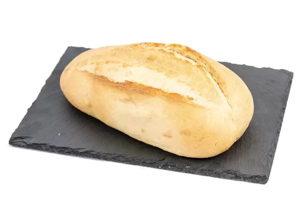 Weißbrot am Stück auf einer dunklen Steinplatte