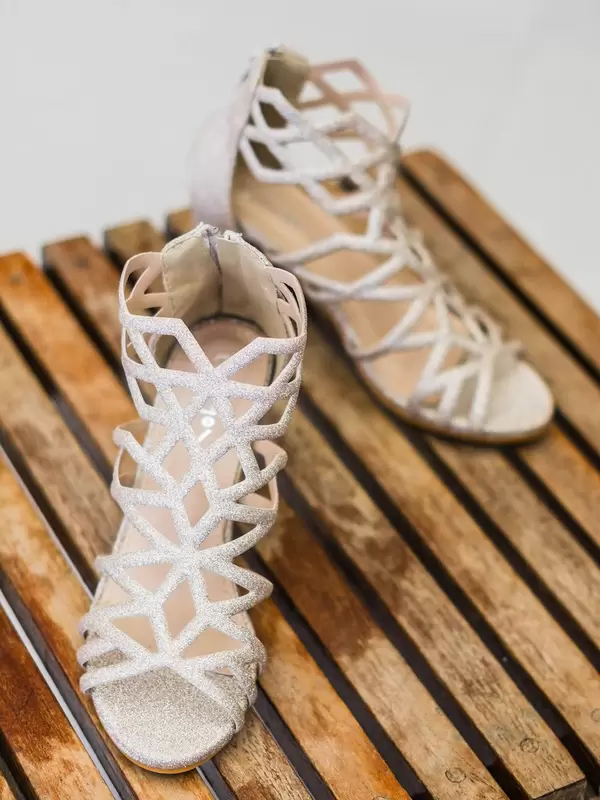 Weiße, moderne Brautschuhe mit Glitzereffekt auf Holztisch