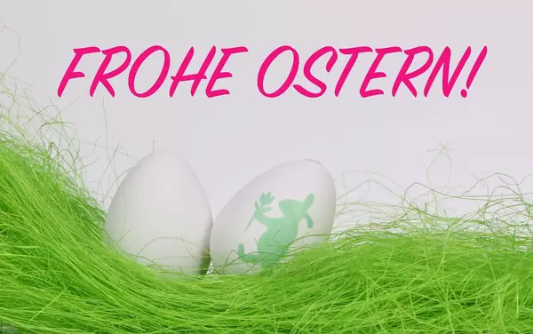 Weiße Ostereier auf grünem Gras vor Text Frohe Ostern auf weißem Hintergrund