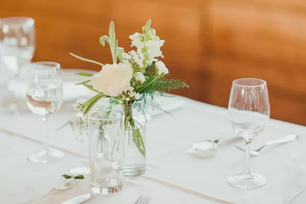 Weiße Rose in einer Glasvase auf einem Hochzeitstisch