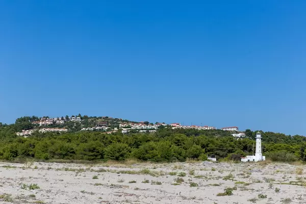 Weißer Leuchtturm unweit vom Strand