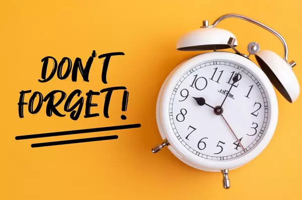 Weißer Wecker mit dem Text ‘Don’t forget!’ vor gelbem Hintergrund