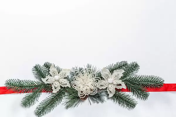 Weißer weihnachtlicher Hintergrund mit Tannenzweig Dekoration und roter Schleife
