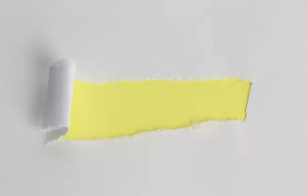 Weißes Papier mit gelben zentralen Loch - Nahaufnahme mit horizontaler Ausrichtung