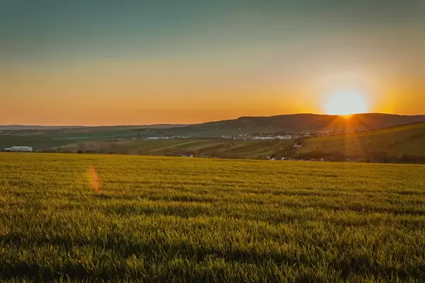 Weite Felder vor einem schönen Sonnenuntergang am Horizont, mit warmen Farben im Süden von Mähren, Tschechien