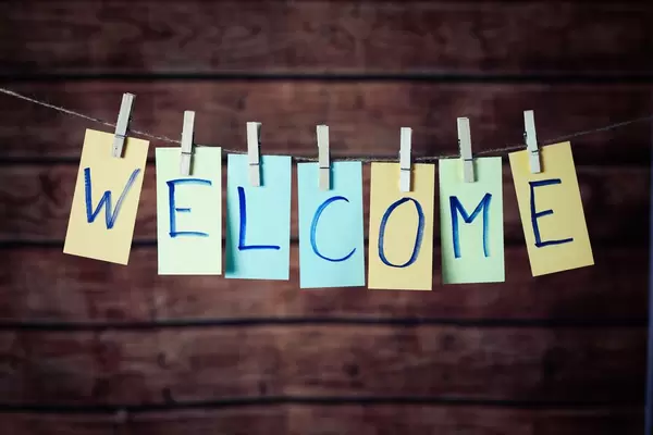 WELCOME Text farbig und hangeschrieben mit Klammern an Leine