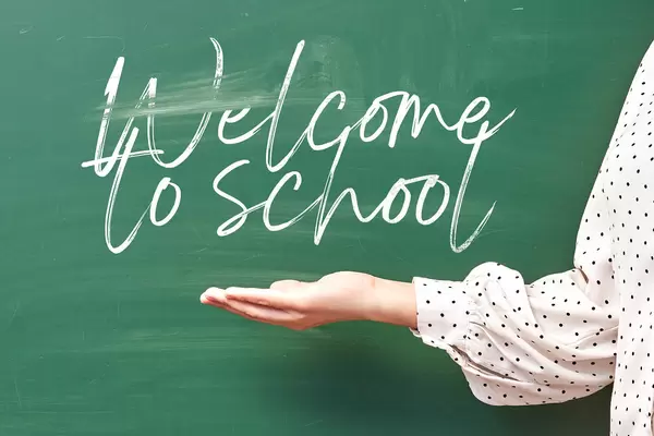 Welcome to school - a teacher welcoming pupils