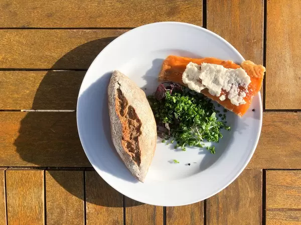 Well-balanced lunch with fish, leek onion salad and a wholemeal bread roll