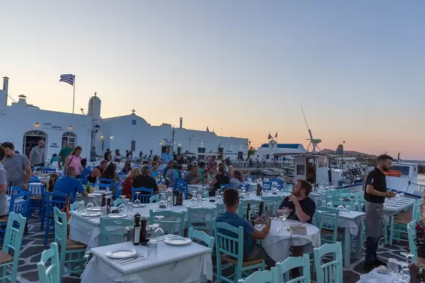 Well visited restaurant terrace at the harbour at sunset on Paros, Greece