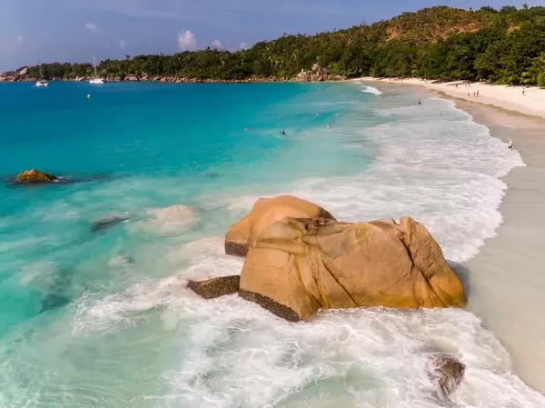 Wellen des Indischen Ozeans brechen am Granitstein neben dem Strand Anse Lazio auf Praslin, Seychellen