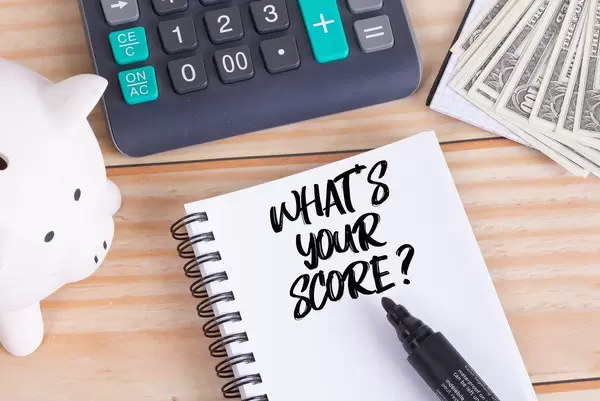 What's your score text in notebook with piggy bank and calculator on wooden table