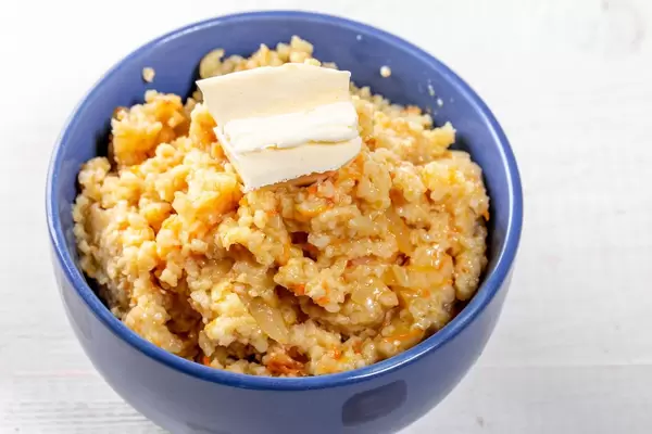 Wheat porridge with a piece of butter in a blue bowl
