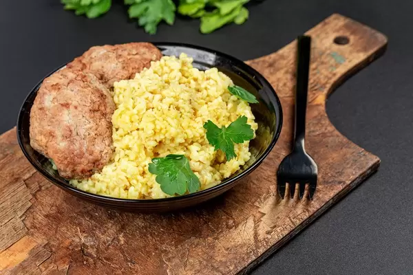 Wheat porridge with fresh parsley and cutlets on a dark background (Flip 2020)