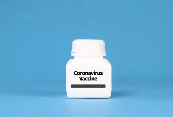 White bottle with Coronavirus Vaccine text on blue background