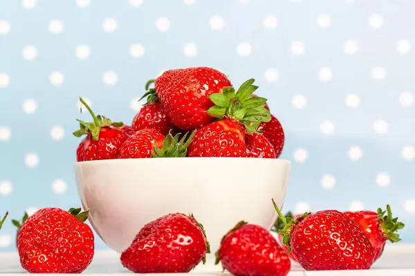 White bowl full of strawberries