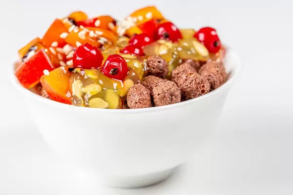 White bowl with corn balls and fruit on a white background (Flip 2020)