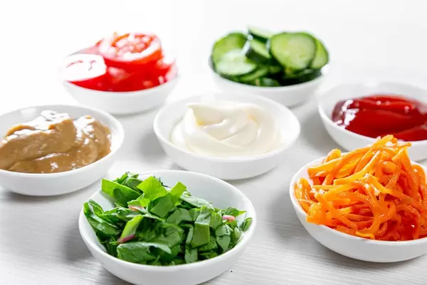 White bowls with sauces, herbs and vegetables