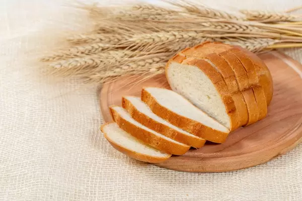 white bread sliced on a kitchen Board with wheat spikelets