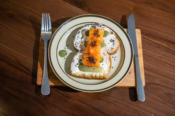 White Bread with Smoked Salmon, Cream Cheese and Pickled Cucumbers as Healthy Brunch in a Cafe