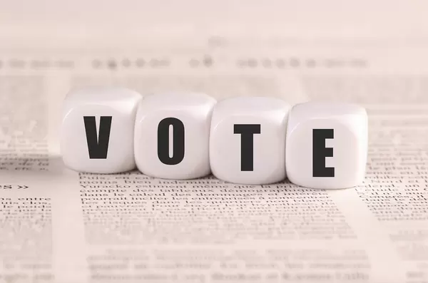 White cubes with Vote text on newspaper