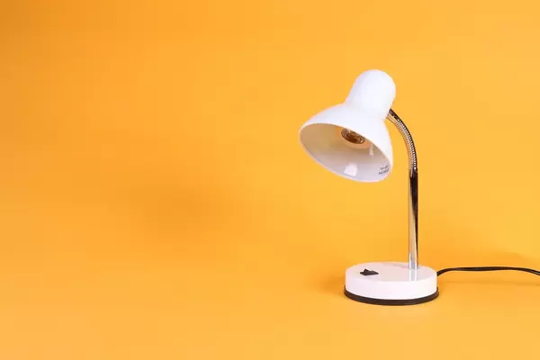 White desk lamp on orange background