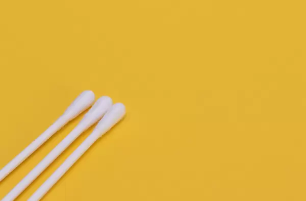 White ear sticks on a yellow background