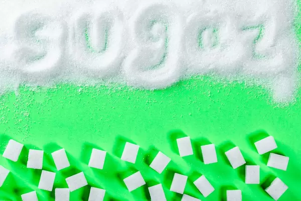 white granulated sugar and refined sugar on a green background with the inscription