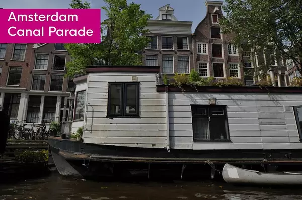 White House boat next to title Amsterdam Canal Parade, that parts in the annual  LGBTQ Amsterdam Pride Parade