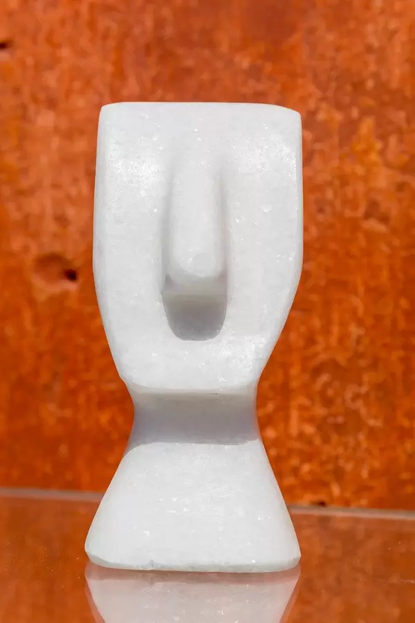 White marble sculpture of a head without eyes and without mouth at Marmairo art gallery in Halki, Naxos