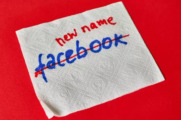 White napkin with handwritten text Facebook and crossed with red. Concept of Facebook name change